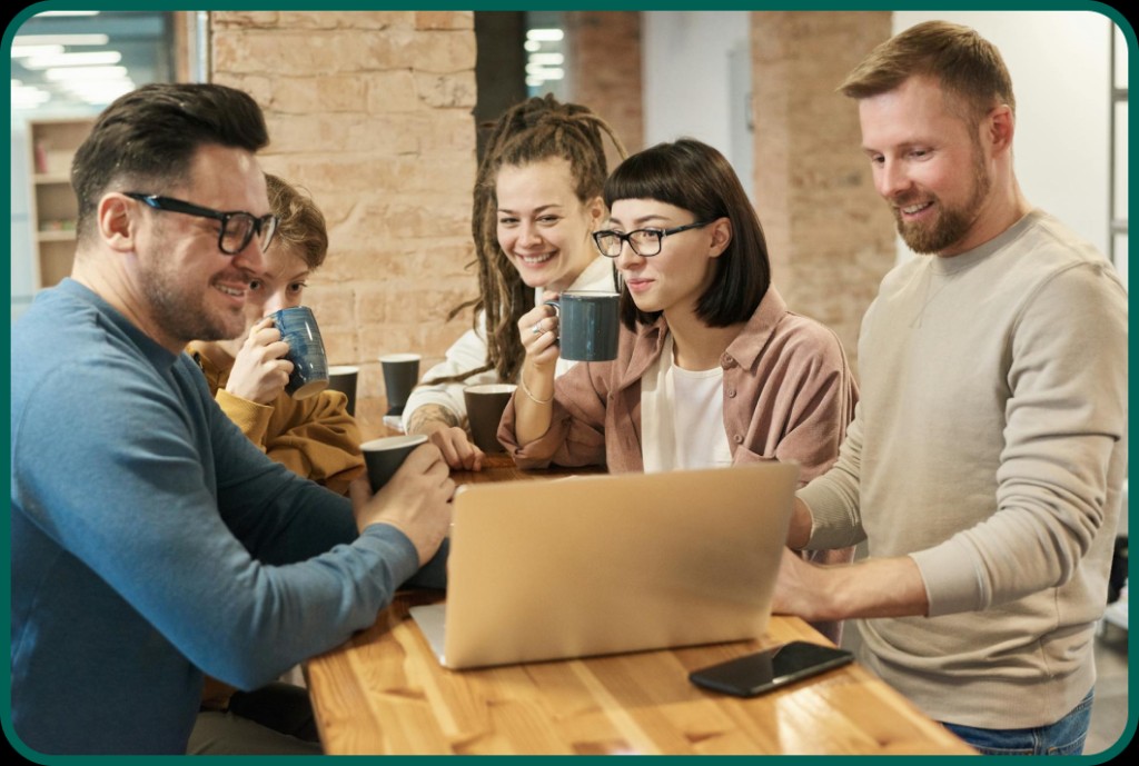 People collaborating around a laptop at a venue